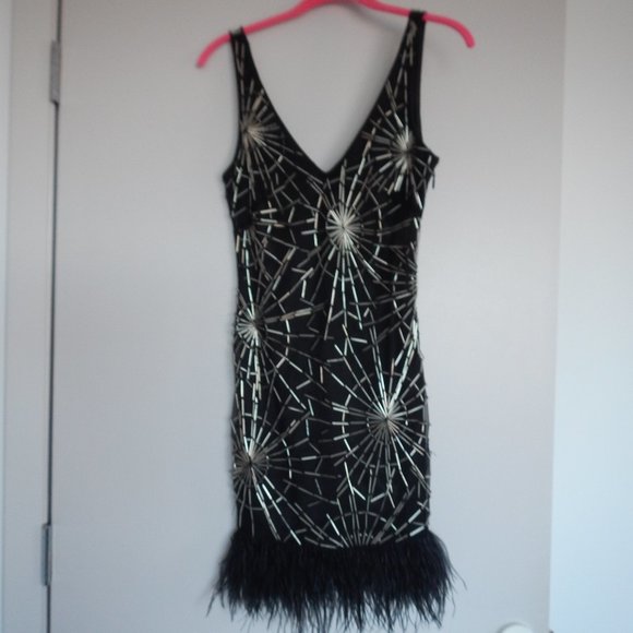 bebe Dresses & Skirts - A BeBe black dress with feathers and metal design.